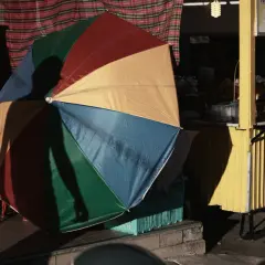 Kolorowy parasol rzuca cień na uliczny stragan z mango sticky rice. Tętniący życiem krajobraz miejski.
