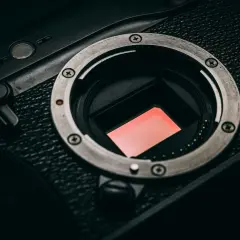 Zbliżenie na matrycę **cmos** aparatu fotograficznego, z widocznym czerwonym filtrem.