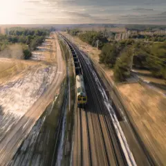 Pociąg towarowy pędzi po torach, krajobraz rozmyty przez efekt panning.