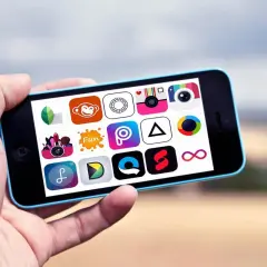 Dłoń trzyma iPhone'a z ikonami aplikacji do obróbki zdjęć iPhone za darmo.